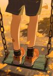  1boy chain child commentary commentary_request evening from_behind ginkgo leaf lower_body male_child male_focus maple_leaf noeyebrow_(mauve) original outdoors playground red_footwear shorts socks solo standing swing 