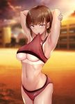  1girl armpits arms_behind_head ass biting blurry blurry_background blush breasts brown_hair crop_top eyebrows_visible_through_hair gentsuki grin highres looking_at_viewer navel original red_eyes short_hair sleeveless smile solo sports_bra sportswear sunset sweat tan tanline track_uniform underboob 