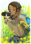  1girl backpack bag black_hair camera camera_around_neck dated day full_body grass green_eyes hair_bobbles hair_ornament highres hirasawa_you holding holding_camera hood hoodie looking_at_viewer original outdoors product_placement shoes short_hair signature smile sneakers solo squatting 