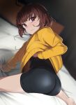  1girl ahoge ass bike_shorts black_bodysuit bodysuit bodysuit_under_clothes brown_hair highres hood hoodie linne looking_at_viewer on_bed purple_eyes short_hair solo touniyuu under_night_in-birth yellow_hoodie 