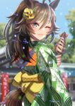  1girl ahoge alternate_hairstyle animal_ears blurry blurry_background brown_hair commentary_request green_kimono hair_ornament hairclip hand_fan highres horse_ears horse_girl horse_tail japanese_clothes kimono looking_at_viewer looking_back medium_hair mr._c.b._(umamusume) obi one_eye_closed otono_(bkt4b) outdoors paper_fan parted_lips ponytail sash smile solo squid tail uchiwa umamusume 