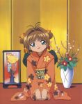  1girl absurdres artist_request brown_hair cardcaptor_sakura child floral_print flower green_eyes hair_flower hair_ornament highres indoors japanese_clothes kero kimono kinomoto_sakura official_art one_eye_closed open_mouth orange_kimono photo_(object) red_flower scan solo_focus 