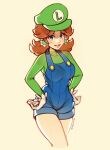  1girl alternate_costume artist_name blue_eyes blue_overalls blush breasts brown_hair buttons cabbie_hat clothes_writing commentary cosplay covered_collarbone cowboy_shot cropped_legs earrings english_commentary flower_earrings gloves green_headwear green_shirt grin hair_flaps hands_on_own_hips happy hat highres jewelry long_sleeves looking_at_viewer luigi luigi_(cosplay) mario_(series) medium_breasts medium_hair overall_shorts overalls oxcoxa parted_bangs princess_daisy shirt sidelocks signature simple_background smile solo standing teeth thighs white_gloves yellow_background 