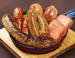  brown_background food food_focus frying_pan highres meat no_humans original sausage still_life tainosuke wood 