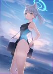 1girl absurdres animal_ears armpits bag bare_legs blue_archive blush breasts competition_swimsuit feet_out_of_frame grey_hair halo highleg highleg_swimsuit highres honome_sui light_smile looking_at_viewer looking_to_the_side medium_breasts mismatched_pupils official_alternate_costume one-piece_swimsuit outdoors ponytail shiroko_(blue_archive) shiroko_(swimsuit)_(blue_archive) shoulder_bag solo swimsuit two-tone_one-piece_swimsuit wolf_ears 
