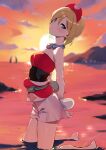  1girl arms_behind_back bare_shoulders barefoot blonde_hair blue_eyes blurry blurry_background blush breasts cloud cloudy_sky commentary_request evening hairband highres irida_(pokemon) kneeling looking_at_viewer ocean orange_sky pokemon pokemon_(game) pokemon_legends:_arceus short_hair shorts sky small_breasts solo sunset wading white_shorts yanagi_(soke_yanagi) 