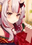  1girl absurdres bell blurry blurry_background blush depth_of_field double_bun frilled_sleeves frills hair_bell hair_bun hair_ornament hand_up highres hololive horns jingle_bell long_hair looking_at_viewer multicolored_hair nakiri_ayame oni oni_horns pom_pom_(clothes) red_eyes red_hair sidelocks skin-covered_horns solo streaked_hair tassel tassel_hair_ornament virtual_youtuber white_hair yomogi_uehara 