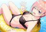  1girl ;d bare_shoulders bikini black_bikini blue_eyes blush breasts cleavage collarbone commentary_request go-toubun_no_hanayome hair_between_eyes hand_up highres innertube kamelie large_breasts looking_at_viewer midriff nakano_ichika navel one_eye_closed open_mouth pink_hair short_hair sidelocks sitting smile solo swimsuit water 