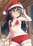  1girl arm_up armpits asashio_(kancolle) bikini black_hair blue_eyes blush breasts commentary_request cowboy_shot fur-trimmed_bikini fur-trimmed_headwear fur_trim furaggu_(frag_0416) hat highres indoors kantai_collection long_hair navel red_bikini red_shorts santa_costume santa_hat shorts small_breasts smile solo swimsuit 