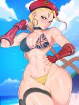  1girl abs beach beret bikini black_choker blonde_hair blue_eyes braid cammy_white choker earrings fingerless_gloves gauntlets gloves hand_on_own_hip hat highres hoop_earrings jewelry minicop2001 muscular muscular_female narrow_waist solo street_fighter swimsuit toned twin_braids union_jack wide_hips 