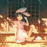  1girl animal_ears arm_support barefoot black_hair blush carrot_necklace crossed_ankles dango dress eating fjsmu flat_chest food frills full_body hand_up highres holding holding_food inaba_tewi jewelry looking_to_the_side necklace outdoors pink_dress puffy_short_sleeves puffy_sleeves rabbit_ears red_eyes shadow short_hair short_sleeves sitting sliding_doors solo toes touhou wagashi 