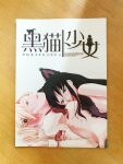  2girls akemi_homura black_hair blonde_hair bra breasts cat_ear_hairband cat_lingerie check_commentary commentary commentary_request content_rating cover cover_page doujin_cover drill_hair frilled_bra frills hair_ornament hairpin highres long_hair looking_at_viewer lying lying_on_person mahou_shoujo_madoka_magica manga_(object) meme_attire mitakihara_school_uniform multiple_girls on_back photo_(medium) purple_bra purple_eyes red_lips school_uniform short_hair tahara_anko tomoe_mami twin_drills underwear yellow_eyes yuri 