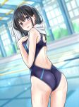  1girl ass awazake_(2wairu) black_hair black_one-piece_swimsuit blurry blurry_background commentary_request competition_swimsuit dutch_angle grey_eyes highres indoors lane_line long_hair looking_at_viewer looking_back one-piece_swimsuit original pool solo standing swimsuit towel towel_around_neck two-tone_swimsuit 