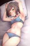  1girl absurdres armpits arms_up bed bed_sheet blue_bra blue_panties blunt_bangs blush bra breasts brown_hair cleavage collarbone commentary_request highres hot kantai_collection kishinami_(kancolle) looking_at_viewer lying navel nuka_(nvkka) on_back on_bed panties parted_lips pillow short_hair small_breasts solo sweat underwear yellow_eyes 