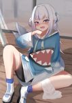 1girl absurdres animal_hood black_shorts blue_eyes blue_hair blue_hood blunt_bangs blush breasts fins fish_tail gawr_gura gawr_gura_(1st_costume) grey_hair hair_ornament highres hololive hololive_english hood looking_at_viewer open_mouth shark_girl shark_hair_ornament shark_hood shark_tail sharp_teeth shoes shorts sidelocks small_breasts sneakers solo sweat tail taruto_(taruto0918) teeth two_side_up upper_teeth_only virtual_youtuber white_footwear wooden_floor 