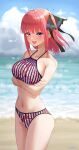  1girl absurdres arms_under_breasts bare_shoulders beach bikini blush breast_hold breasts butterfly_hair_ornament cloud cloudy_sky cowboy_shot crossed_arms day floral_print go-toubun_no_hanayome hair_ornament halterneck highres horizon large_breasts looking_at_viewer medium_hair nakano_nino navel ocean one_side_up open_mouth pink_hair purple_eyes red_bikini sand sideboob signature sky solo standing striped striped_bikini swimsuit teeth thighs upper_teeth_only vertical-striped_bikini vertical_stripes yuhi_(yuhi_atb26) 