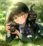  1girl black_cat bow bowtie camera cat ear_piercing earrings green_eyes green_hair green_jacket highres holding holding_camera jacket jewelry looking_at_viewer lying on_grass on_stomach original piercing pleated_skirt red_bow red_bowtie single-lens_reflex_camera skirt smile solo tasuku_(otomebotan) viewfinder 