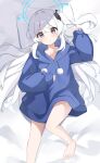  1girl absurdres bed_sheet blue_archive blue_halo blue_hoodie blush collarbone foot_out_of_frame grey_hair hair_between_eyes halo highres hood hoodie long_hair long_sleeves looking_at_viewer miyako_(blue_archive) official_alternate_costume one_side_up parted_lips pillow purple_eyes solo yoi0341 