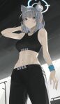  1girl :o abs absurdres alternate_costume animal_ear_fluff animal_ears arm_up black_pants black_sports_bra blue_archive blush breasts commentary extra_ears grey_hair gym halo highres indoors looking_at_viewer medium_breasts mismatched_pupils mm_(mhm2592) navel pants shiroko_(blue_archive) solo sports_bra stomach sweat wolf_ears wristband 