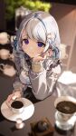  1girl amanai_daisy aora_cafe apron arcanakit_v blue_eyes blue_hair blurry blush braid breasts closed_mouth coffee commentary_request commission cup depth_of_field frills grey_hair grey_shirt hair_ornament hairclip head_rest highres holding holding_cup indoors large_breasts long_hair long_sleeves looking_at_viewer multicolored_hair plate shirt smile solo streaked_hair virtual_youtuber white_apron wrist_cuffs 