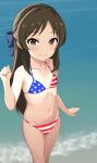  1girl american_flag_bikini baji_toufuu_(bajitohfu) beach bikini bow brown_eyes brown_hair feet_out_of_frame flag_print flat_chest hair_bow half_updo highres idolmaster idolmaster_cinderella_girls idolmaster_cinderella_girls_u149 long_hair navel smile solo star_(symbol) star_print striped striped_bikini swimsuit tachibana_arisu waves 