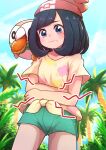  1girl beanie black_hair blush closed_mouth cloud commentary_request day eyelashes floral_print frown green_shorts hat highres kotobukkii_(yt_lvlv) looking_at_viewer on_shoulder outdoors palm_tree pokemon pokemon_(creature) pokemon_(game) pokemon_on_shoulder pokemon_sm red_headwear rowlet selene_(pokemon) shirt short_shorts short_sleeves shorts sky stomach_growling t-shirt tied_shirt tree 