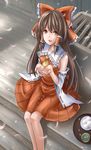  bad_id bad_pixiv_id bon bow box brown_eyes brown_hair detached_sleeves donation_box food from_above hair_bow hakurei_reimu highres long_hair open_mouth outstretched_hand petals sitting smile solo touhou veranda 