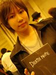  artist_request asian bangs brown_hair cosplay crossdressing death_note death_note_(object) dutch_angle holding lowres photo solo_focus yagami_light yagami_light_(cosplay) 