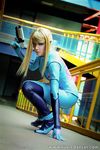  absurdres blonde_hair blue_eyes cosplay highres kneeling metroid nintendo photo ponytail samus_aran weapon yukilefay zero_suit 