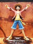  1boy abs black_hair figure hat jolly_roger male male_focus monkey_d_luffy one_piece open_clothes open_shirt outstretched_arms photo pirate red_shirt sandals sash scar shirt shorts smile solo spread_arms standing straw_hat 