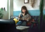  1girl absurdres blurry_foreground book brown_eyes brown_hair cactus cake couch cup denim food highres idarintarou indoors jeans long_hair long_sleeves mug open_book original painting_(object) pants pillow plant potted_plant reading restaurant sitting solo table 