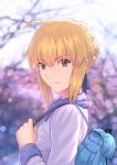  1girl ahoge artoria_pendragon_(all) bag blonde_hair blue_ribbon blurry blurry_background braided_bun day eyebrows_visible_through_hair fate/stay_night fate_(series) fateline_alpha green_eyes hair_between_eyes hair_ribbon highres holding holding_bag long_sleeves looking_at_viewer outdoors ribbon saber short_hair sidelocks smile solo white_coat 