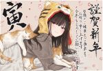  1girl akipeko animal_hood black_hair blanket blush border brown_eyes cat commentary_request floral_background grey_sweater half-closed_eyes highres hood light_smile long_hair long_sleeves looking_at_viewer lying on_stomach original outside_border pillow sleeping solo sweater tiger_hood translation_request under_covers white_border 