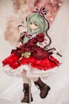  1girl adapted_costume arm_ribbon blurry blurry_background boots brown_footwear character_doll cross-laced_footwear doll doll_joints dress frilled_dress frills front_ponytail full_body green_eyes green_hair hair_ribbon hand_up highres joints kagiyama_hina kneehighs lace-trimmed_dress lace-trimmed_ribbon lace-up_boots lace_socks lace_trim long_hair looking_at_viewer miyako_sasara nail_polish petticoat photo_(medium) puffy_short_sleeves puffy_sleeves red_dress red_nails red_ribbon ribbon short_sleeves socks solo standing standing_on_one_leg touhou volks_dd white_socks 