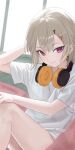  1girl absurdres hair_ornament hairclip headphones headphones_around_neck highres komori_met looking_at_viewer medium_hair mito_(dncs8244) no_pants purple_eyes shirt short_sleeves sitting solo t-shirt thighs virtual_youtuber vspo! white_shirt window 