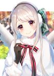  1girl bangs black_gloves blurry blurry_background blush bow capelet closed_mouth commentary_request depth_of_field earmuffs elu_(nijisanji) eyebrows_visible_through_hair fur-trimmed_capelet fur_trim gloves green_bow hair_bow hand_up head_tilt highres long_hair long_sleeves nijisanji omelet_tomato red_eyes silver_hair smile solo striped striped_bow upper_body very_long_hair virtual_youtuber white_capelet white_coat 