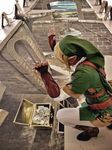  belt blonde_hair boots chalk chobitsg cosplay crouch gauntlets hat link photo pointy_ears solo squatting the_legend_of_zelda 