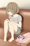  :t barefoot blush book brown_hair clothes_writing collarbone couch fidgeting full_body green_eyes hands_on_own_knees indoors mattaku_mousuke motion_lines open_book original pout shirt short_hair short_sleeves shorts sitting solo t-shirt 