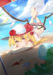  ball beach beach_umbrella beachball blonde_hair blush cloud day dutch_angle emushake flandre_scarlet flower grin hat hat_flower hat_ribbon highres horizon long_hair looking_at_viewer lying ocean on_stomach outdoors red_eyes red_flower red_rose ribbon rose shade side_ponytail sky smile solo swimsuit touhou umbrella wings 