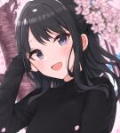  1girl black_hair black_shirt blurry blurry_foreground blush breasts cherry_blossoms dot_nose falling_petals hand_on_own_face hand_up hanetsuka highres idolmaster idolmaster_shiny_colors kazano_hiori long_hair long_sleeves looking_at_viewer mole mole_under_mouth open_mouth outdoors petals ponytail purple_eyes shirt small_breasts smile solo upper_body 