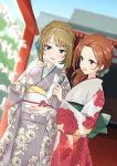  2girls arm_up blue_sky blurry brown_eyes commentary_request cowboy_shot day depth_of_field dutch_angle floral_print flower green_eyes hair_flower hair_ornament hair_up holding holding_paper idolmaster idolmaster_cinderella_girls japanese_clothes kawashima_mizuki kimono light_brown_hair long_sleeves looking_at_viewer looking_to_the_side mole multiple_girls obi omikuji open_mouth outdoors paper ponytail red_hair sash sky standing takagaki_kaede torii wide_sleeves zerorou_(himitunoko2) 