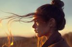 artist_name astri_lohne_sjursen blurry brown_eyes brown_hair closed_mouth commentary depth_of_field earrings freckles from_side hair_bun jewelry long_hair original outdoors photo-referenced portrait profile realistic sky solo sunset wind 