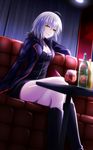  ahoge black_dress black_footwear blonde_hair boots bottle breasts cleavage crossed_legs dress fate/grand_order fate_(series) fur_trim highres jeanne_d'arc_(alter)_(fate) jeanne_d'arc_(fate)_(all) jewelry knee_boots medium_breasts necklace nya_rl short_dress short_hair smile solo wicked_dragon_witch_ver._shinjuku_1999 wine_bottle yellow_eyes 