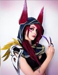  1girl animal_ears cosplay feather hood league_of_legends lipstick long_hair looking_at_viewer makeup photo red_hair skull solo xayah 