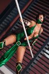  1girl black_hair cleavage cosplay dark_skin face_mask green_eyes half_mask holding_weapon jade_(mortal_kombat) mortal_kombat no_bra photo staff very_long_hair 