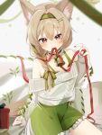  1girl absurdres animal_ear_fluff arknights beanstalk_(arknights) beanstalk_(gift_uncompleted)_(arknights) bell braid dress frilled_dress frills green_dress green_hairband green_nails hair_between_eyes hair_ornament hairband hairclip highres hyena_ears hyena_girl looking_at_viewer mouth_hold multicolored_nails nail_polish neck_bell nishimiya_aki off-shoulder_sweater off_shoulder official_alternate_costume red_eyes red_nails red_ribbon ribbon side_braid single_braid sitting sleeves_past_wrists solo sweater white_sweater 