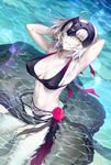  ahoge arms_behind_head arms_up artist_name bangs bikini black_bikini breasts cleavage commentary_request fate/grand_order fate_(series) flower grin hands_in_hair headpiece jeanne_d'arc_(alter)_(fate) jeanne_d'arc_(fate)_(all) kousaki_rui large_breasts looking_at_viewer looking_to_the_side navel pale_skin partially_submerged red_flower red_rose rose sarong short_hair signature silver_hair smile solo swimsuit water water_drop yellow_eyes 