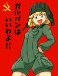  aono3 arm_behind_back bangs blonde_hair blue_eyes cowboy_shot emblem eyebrows_visible_through_hair fang girls_und_panzer green_jumpsuit hand_on_hip helmet highres katyusha long_sleeves looking_at_viewer military military_uniform open_mouth pravda_(emblem) pravda_military_uniform red_background short_hair short_jumpsuit simple_background smile solo translated uniform 
