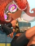  1girl animal_print armor bare_shoulders black_gloves black_shorts breastplate dark-skinned_female dark_skin elbow_gloves fingerless_gloves ganguro gloves goggles green_eyes highres horizontal_pupils leopard_print octoling otoboke-san parted_lips pink_lips red_hair shorts sitting solo splatoon_(series) splatoon_3 takozonesu tentacle_hair 