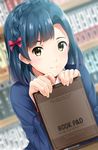  asymmetrical_bangs bangs bashosho blue_hair blurry blurry_background blush bookshelf braid closed_mouth commentary_request crown_braid depth_of_field dutch_angle eyebrows_visible_through_hair green_eyes hair_ribbon highres idolmaster idolmaster_million_live! indoors long_sleeves nanao_yuriko pink_ribbon ribbon short_hair smile solo tablet tareme upper_body 